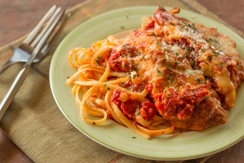 Hot and crispy chicken parmesan in savory red tomato sauce