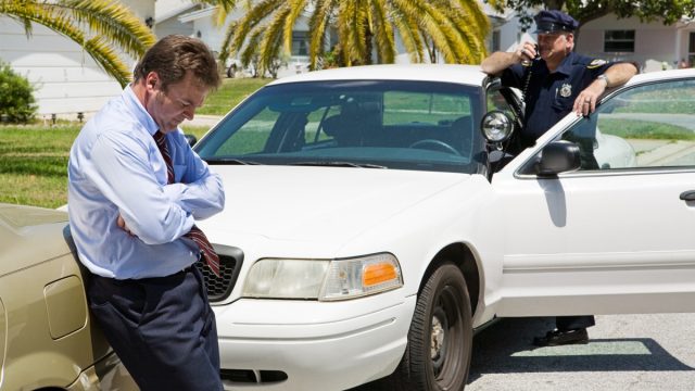 Embarrassed looking businessman pulled over by the police.
