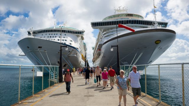 Passengers disembarking from two cruise ships on a dock