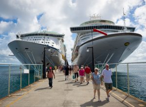 Passengers disembarking from two cruise ships on a dock