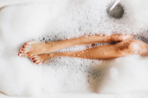 image of a woman's legs in a bubble bath