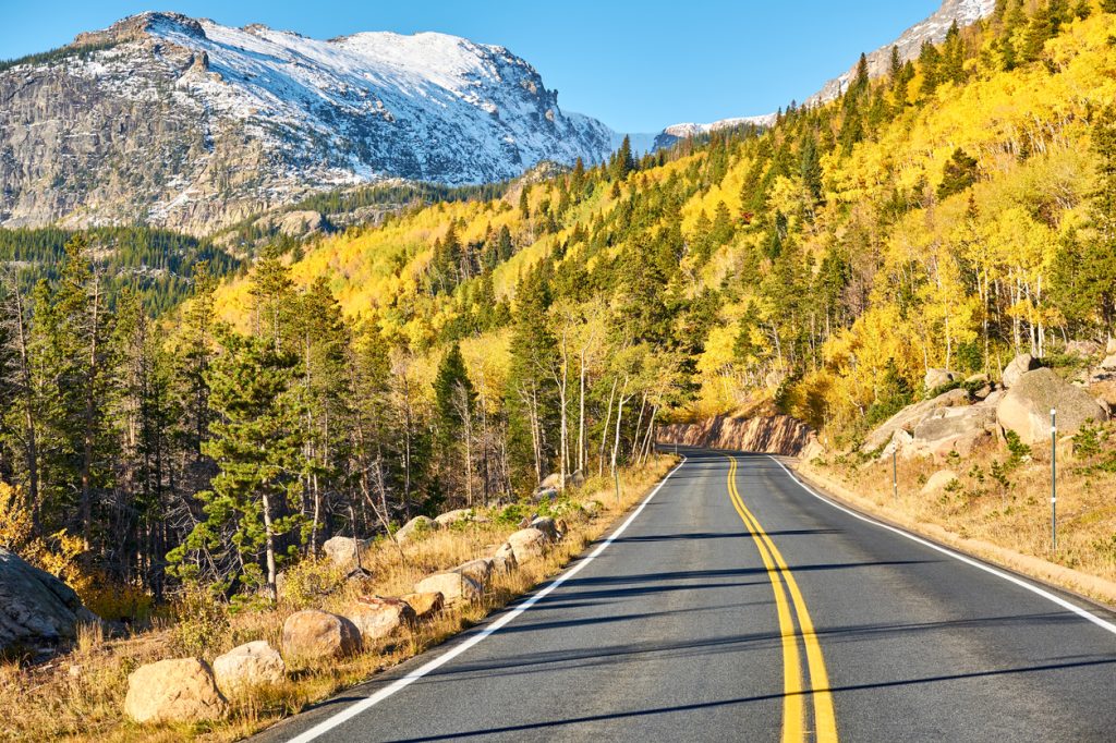 A road passing through Rocky Mountain National Park surrounded by fall foliage