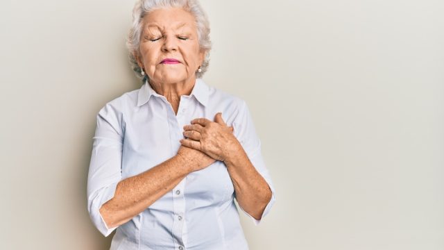 Older Woman Clutching Chest