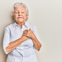 Older Woman Clutching Chest