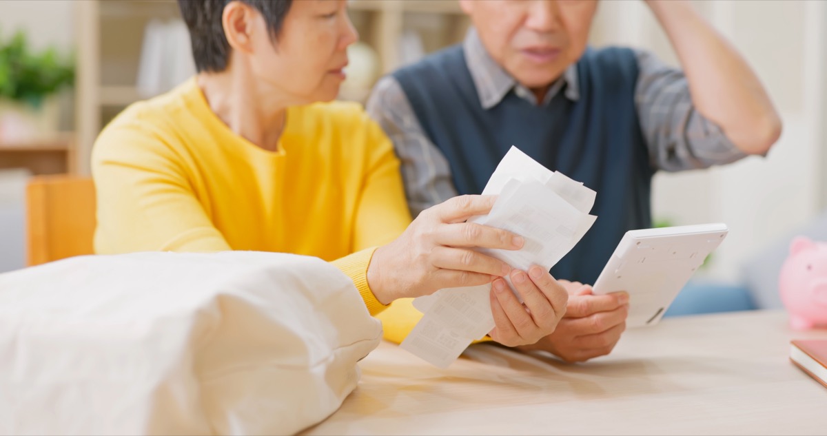 elderly couple looking at receipts