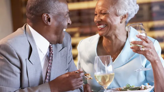 older couple laughing having dinner