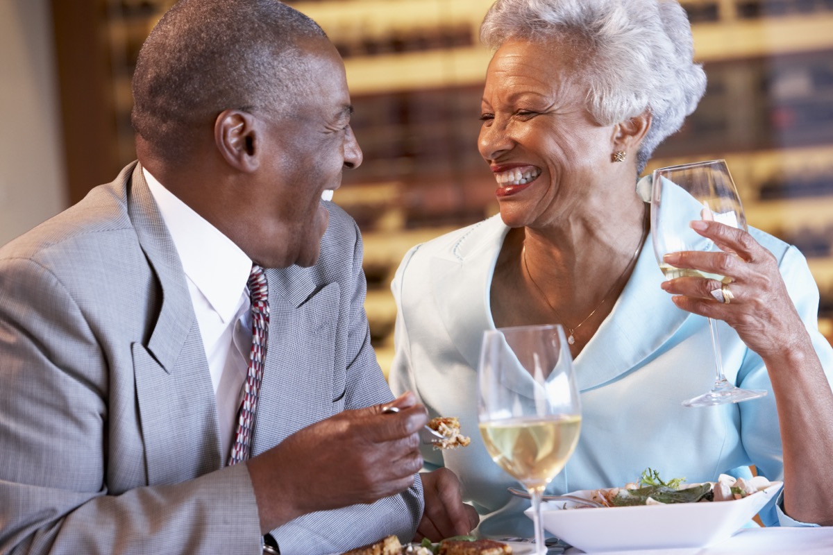 older couple laughing having dinner