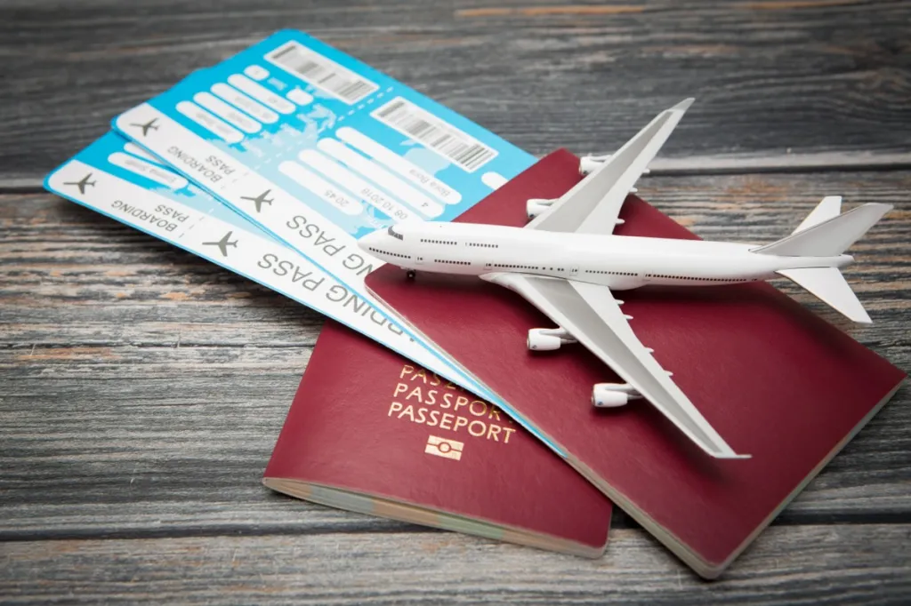 A model plane on top of a pair of passports and boarding passes