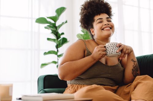 young woman smiling and drinking tea