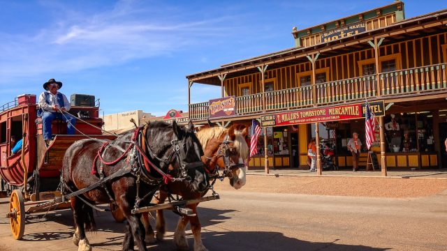 A stagecoach filled with tourists travels the historic streets of Tombstone, Arizona