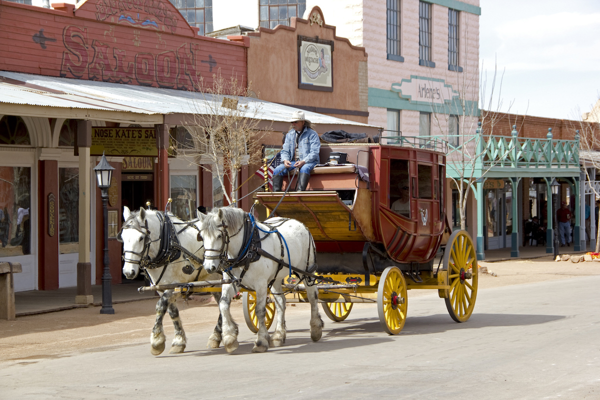 A stagecoach drawn by two horses goes down the street in Tombstone, Arizona, a Wild West town.