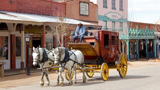 A stagecoach drawn by two horses goes down the street in Tombstone, Arizona, a Wild West town.