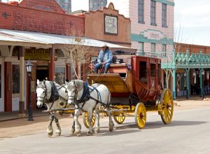 A stagecoach drawn by two horses goes down the street in Tombstone, Arizona, a Wild West town.