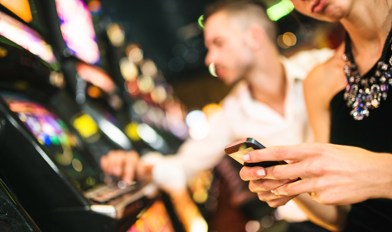 A close up of a person using their smartphone in a casino