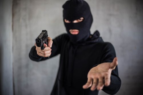Bandit carrying a gun, wearing a black mask.