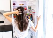 A woman looking into her refrigerator or freezer for food