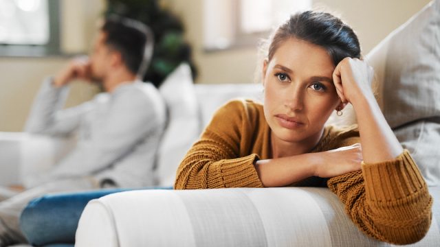 Shot of a young woman ignoring her boyfriend after having an argument on the couch