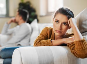 Shot of a young woman ignoring her boyfriend after having an argument on the couch