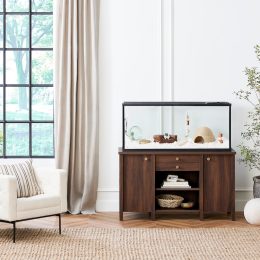 A living room featuring a dark wood stand and hamster cage designed for Nate Berkus and Jeremiah Brent's small animal collection at PetSmart.