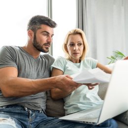 Mid adult couple having problems with home financials. Using laptop and paying bills.