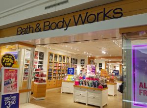 The entrance to a Bath & Body Works store in the mall with signs advertising a sale.