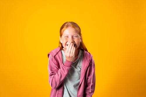 10-year-old girl laughing at a joke