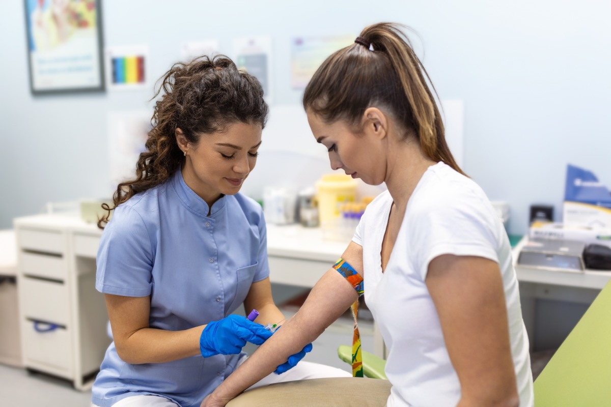 Female nurse about to take a blood sample from a young female patient