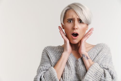 woman looking shocked with hands by her face