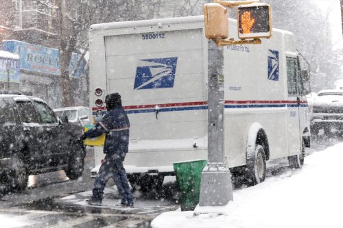 Mailman with package during snow storm. Taken January 7, 2017 in New York.