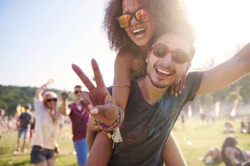man giving woman a piggyback at a music festival