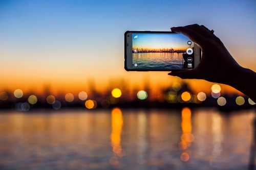 taking a photo of the sunset on cellphone