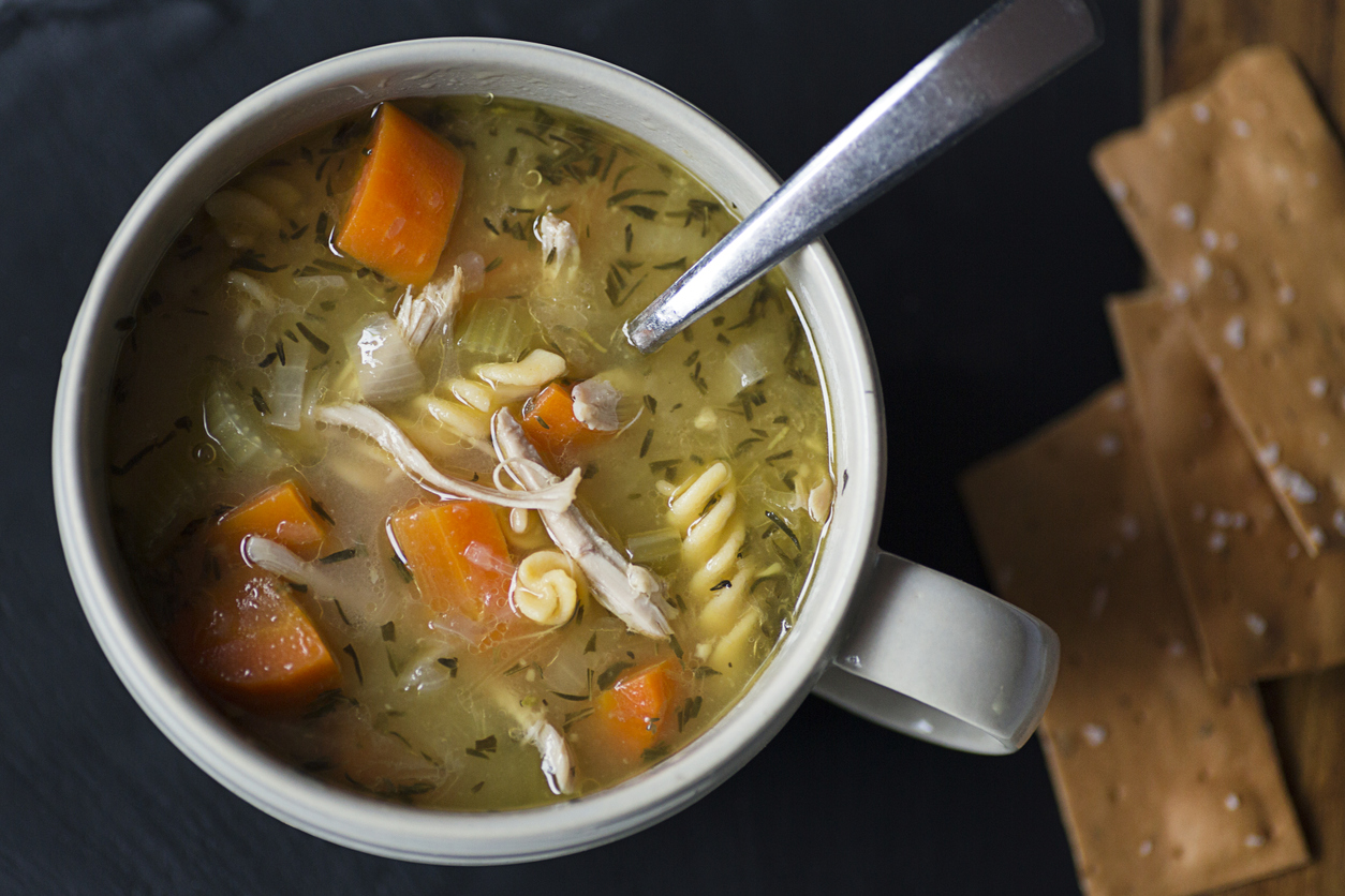 Homemade chicken noodle soup with carrots and crackers