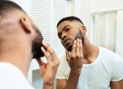 Man examining his face in the mirror.