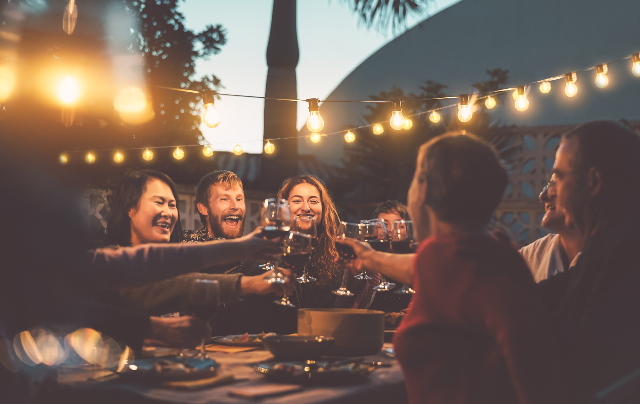 Gia đình hạnh phúc ăn thức ăn và nếm ly rượu vang đỏ trong bữa tiệc thịt nướng - Những người ở các độ tuổi và sắc tộc khác nhau vui vẻ cùng nhau - Thanh niên và cha mẹ già và khái niệm hoạt động cuối tuần về ẩm thực