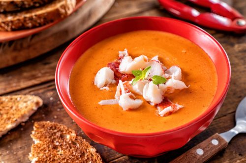 A bowl of delicious creamy lobster bisque with lobster meat, tomato paste, cream and cognac.