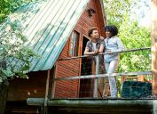 Couple standing outside cabin at start of weekend getaway