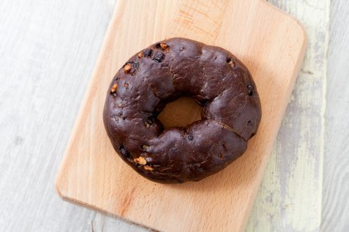 Chocolate Bagel and tea cup on wooden plate