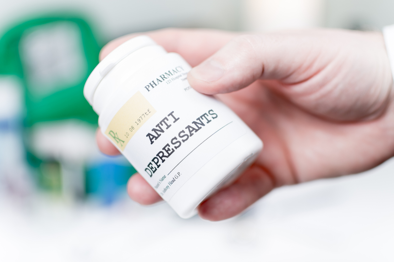 Person holding a bottle of antidepressants.