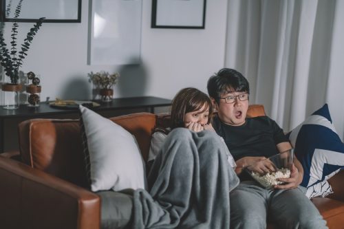 asian couple watching horror movie