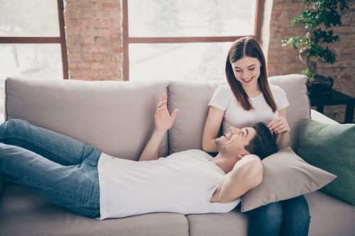 man laying in woman's lap on couch