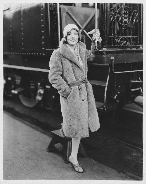 Lupe Vélez standing next to a train circa 1929