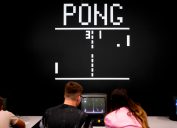 Visitors play the retro game "Pong" at the Video games trade fair Gamescom in Cologne.