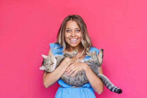 woman holding cat and smiling