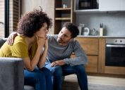 man comforting his girlfriend at home while she is looking upset - lifestyle concepts