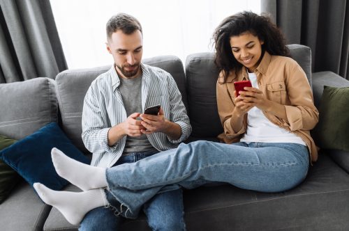 couple on couch using their phones