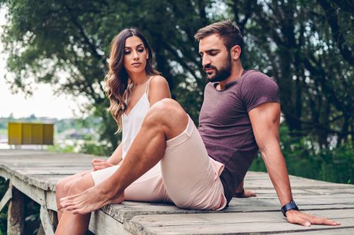 couple sitting on dock looking tense discussing relationship deal breakers