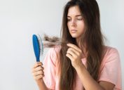 Young Woman Pulling Hair Out of a Brush