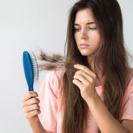 Young Woman Pulling Hair Out of a Brush