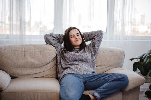 woman leaning back on the couch alone