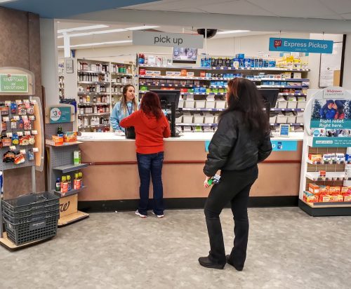people waiting in line at walgreens pharmacy